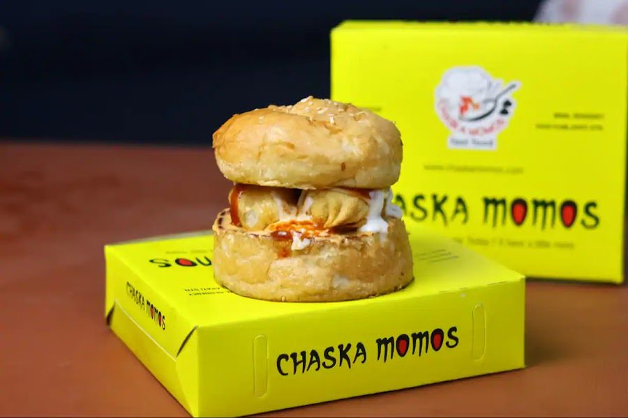 Paneer momo burger with a Chaska Momos box