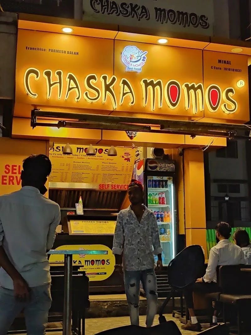 Chaska Momos outlet front with lit yellow sign