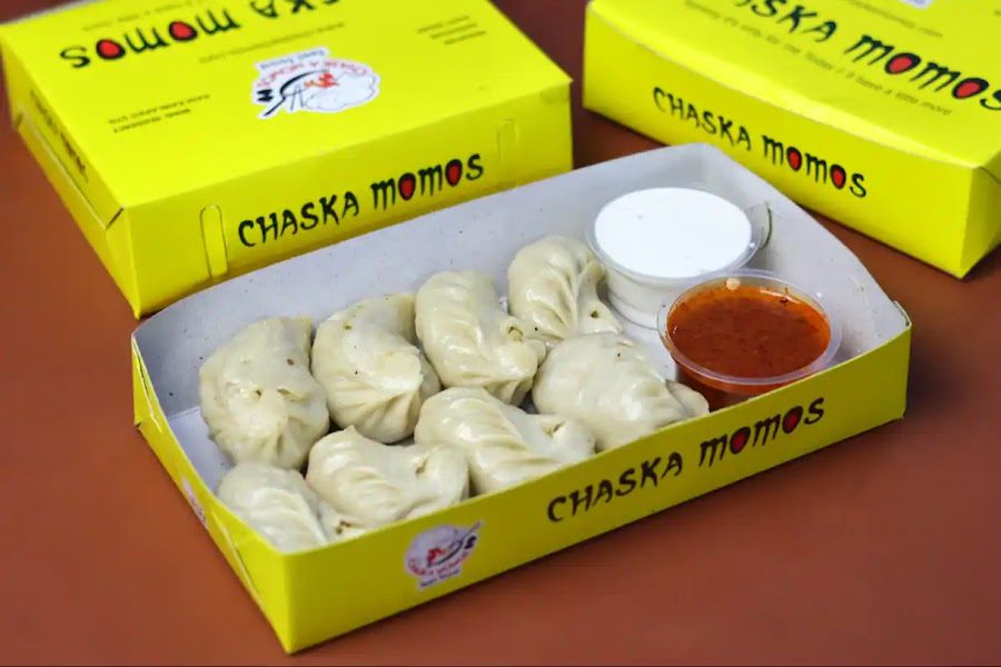 Steamed momos in a Chaska Momos box with chutney and mayo